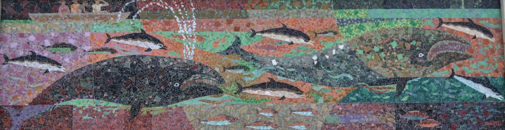 Whale & dolphin mosaic above side entrance - signed "S. Hertel"